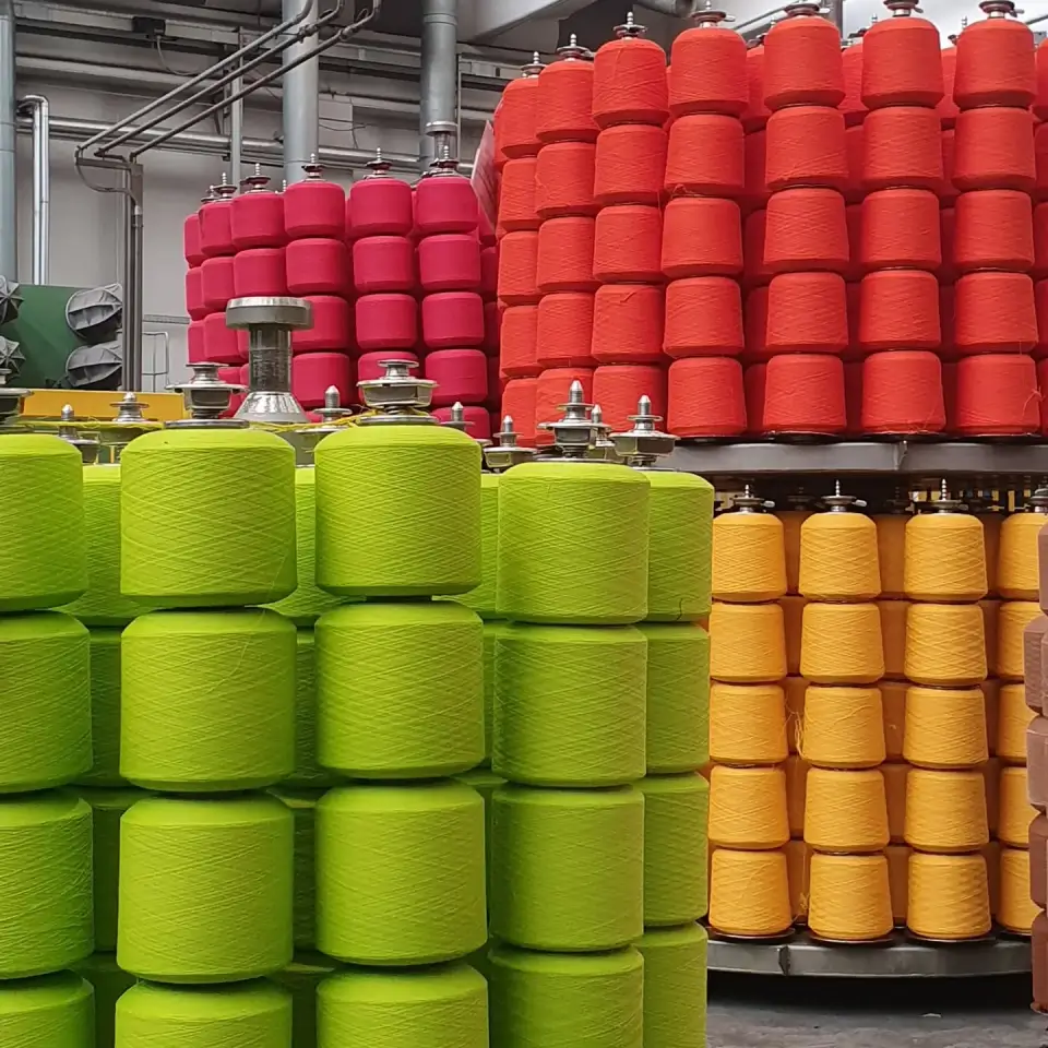 Bobine industriali colorate in un impianto di produzione tessile