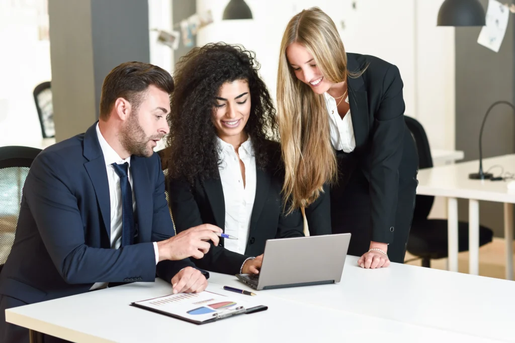 Team commerciale PMI che lavora insieme al sistema di vendita con laptop e dashboard
